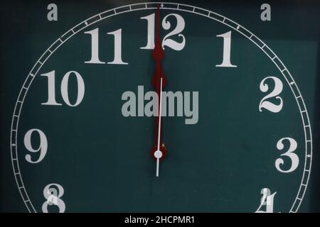 Frohes Neues Jahr! Zwölf`Uhr auf grüner Uhr mit Zahlen aus der Nähe Stockfoto